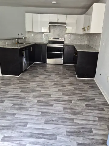 a kitchen with granite countertop a stove and cabinets