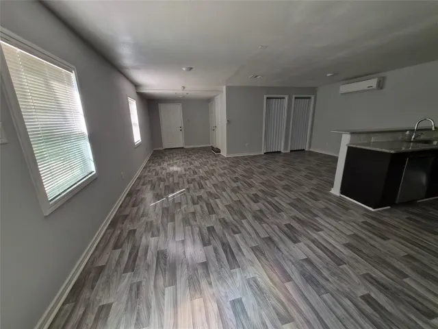 a big room with wooden floor and windows