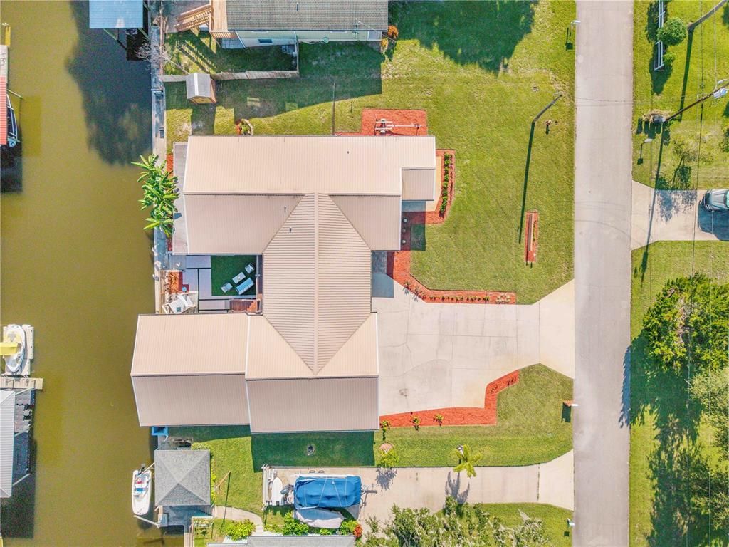 an aerial view of a house with swimming pool and large trees