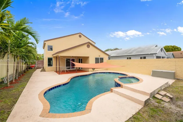 a kitchen with stainless steel appliances a table chairs refrigerator and cabinets