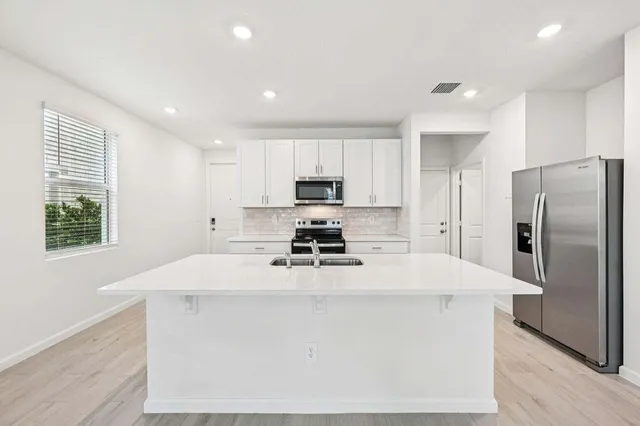 a kitchen with kitchen island a stove a sink and a refrigerator