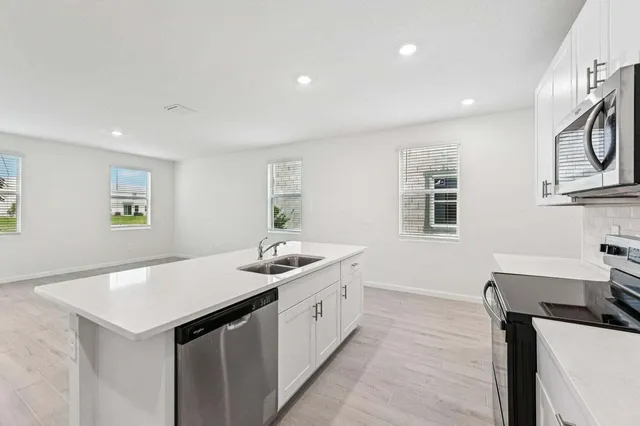 a view of kitchen island sink refrigerator and wooden floor