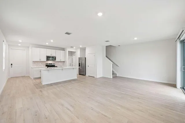 a view of kitchen with kitchen island white cabinets and stainless steel appliances