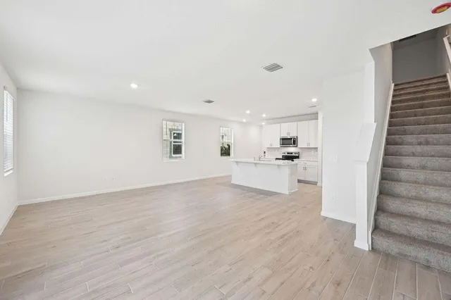 a view of a kitchen with wooden floor and electronic appliances