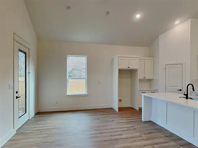 a large kitchen with stainless steel appliances a lot of counter space and wooden floor