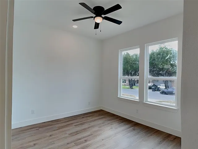 an empty room with a window and a ceiling fan