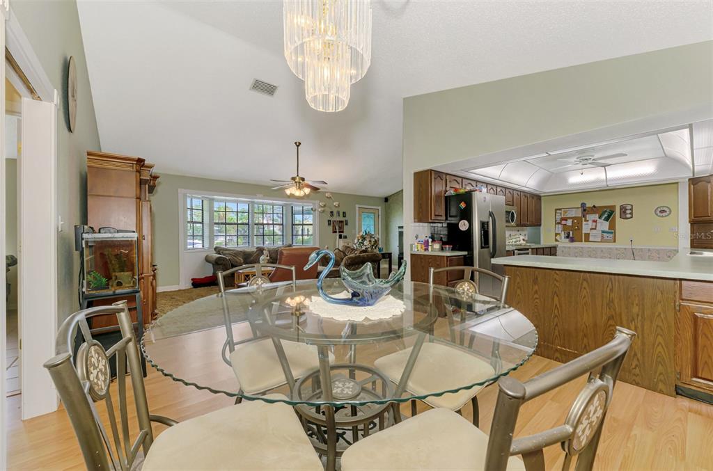 1137 Ponderosa Road Venice, FL 34293 - Photo 14 of 48 a dining room with furniture a chandelier and kitchen view