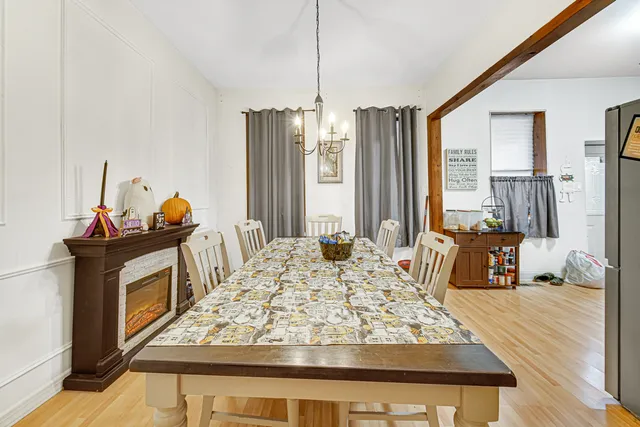 a view of a dining room with furniture a chandelier and wooden floor