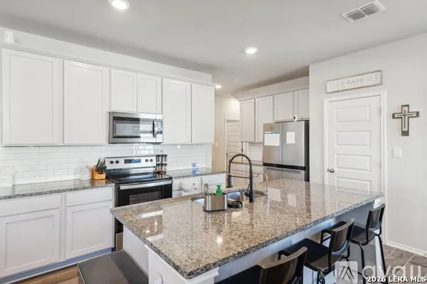 a kitchen with stainless steel appliances granite countertop a stove a sink a microwave and refrigerator