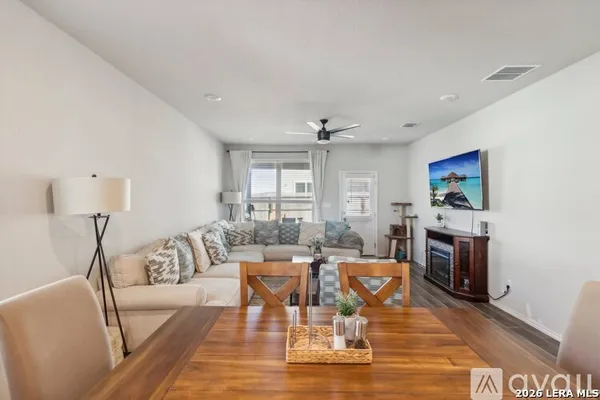 a living room with furniture a flat screen tv and a fireplace