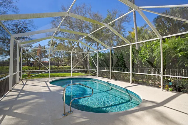 a view of a backyard with swimming pool and wooden fence