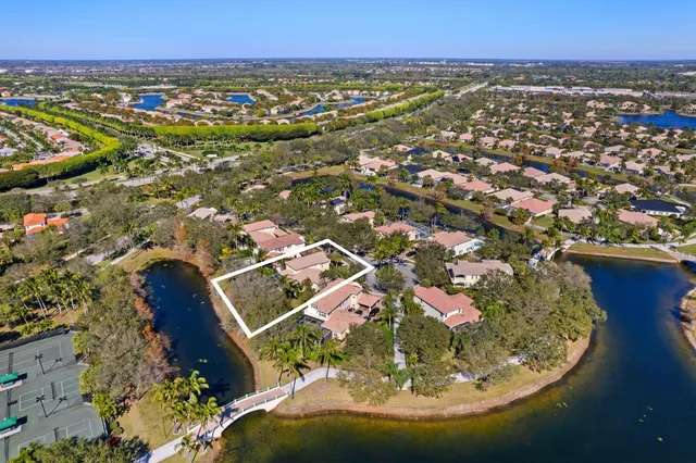 an aerial view of residential houses with outdoor space and trees