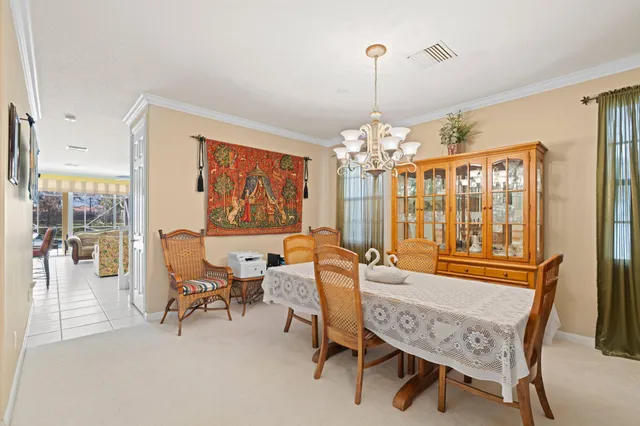 a dining room with furniture a chandelier and wooden floor