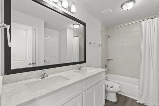 a bathroom with a granite countertop sink a toilet and a bathtub