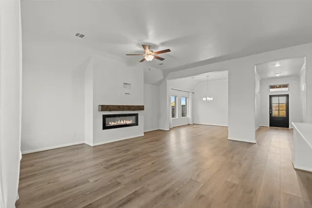 a view of an empty room with window and wooden floor