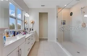 a bathroom with a double vanity sink mirror double and shower