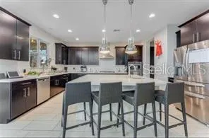 a kitchen with stainless steel appliances kitchen island granite countertop a kitchen island and chairs in it