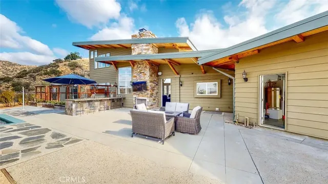 a view of a patio with a table and chairs under an umbrella