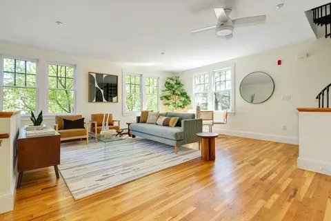 a living room with fireplace furniture and a large window