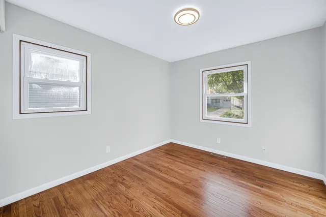 a view of empty room with wooden floor