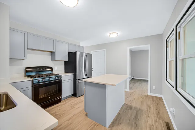 a kitchen with stainless steel appliances a stove a sink and a refrigerator