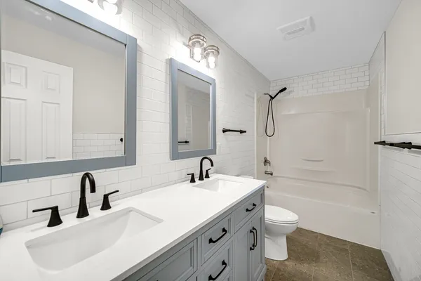 a bathroom with a sink a toilet and a large mirror