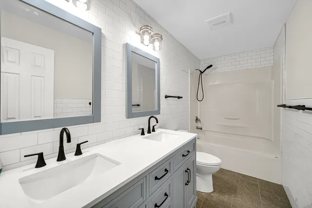 a bathroom with a sink a toilet and a large mirror