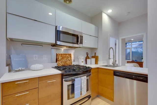 a kitchen with stainless steel appliances granite countertop a stove a sink and a microwave