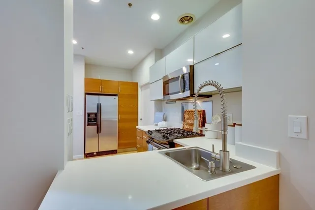 a kitchen with stainless steel appliances a sink stove and refrigerator