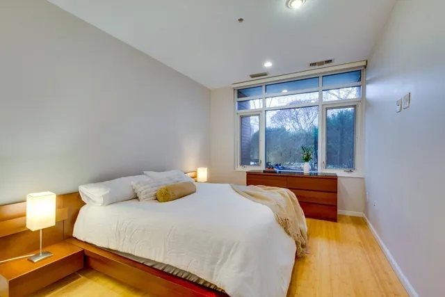 a bedroom with a bed and wooden floor