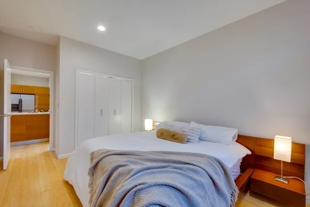 a bedroom with a bed and wooden floor