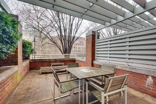a roof deck with a table and chairs and potted plants