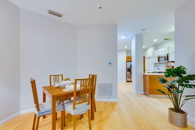 a view of a dining room with furniture and a potted plant