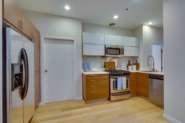 a kitchen with stainless steel appliances granite countertop a stove a refrigerator and a sink
