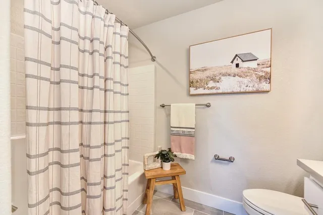 a bathroom with a toilet and a shower curtain