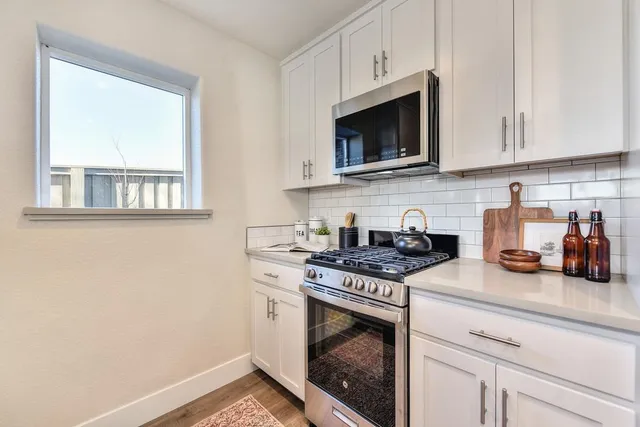 a kitchen with stainless steel appliances granite countertop a sink stove and microwave