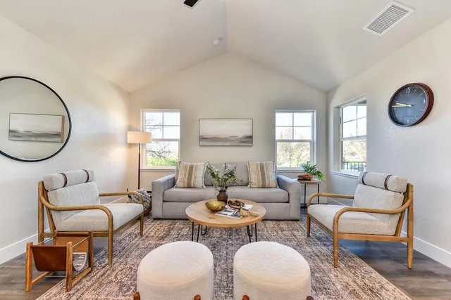 a living room with fireplace a mirror and a table