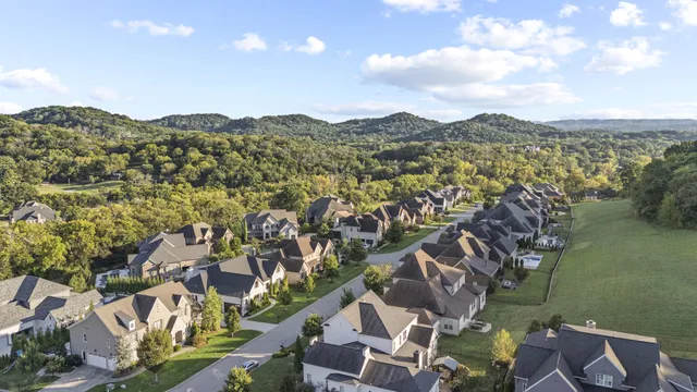 an aerial view of residential house with outdoor space and trees