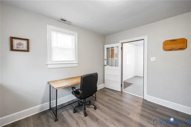 a view of a workspace with furniture and a window