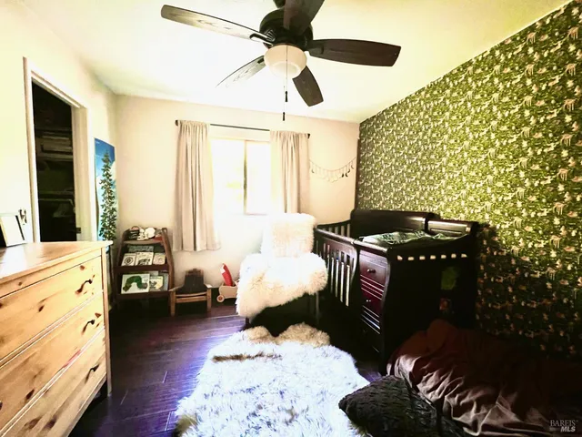 a bedroom with bed and wooden floor