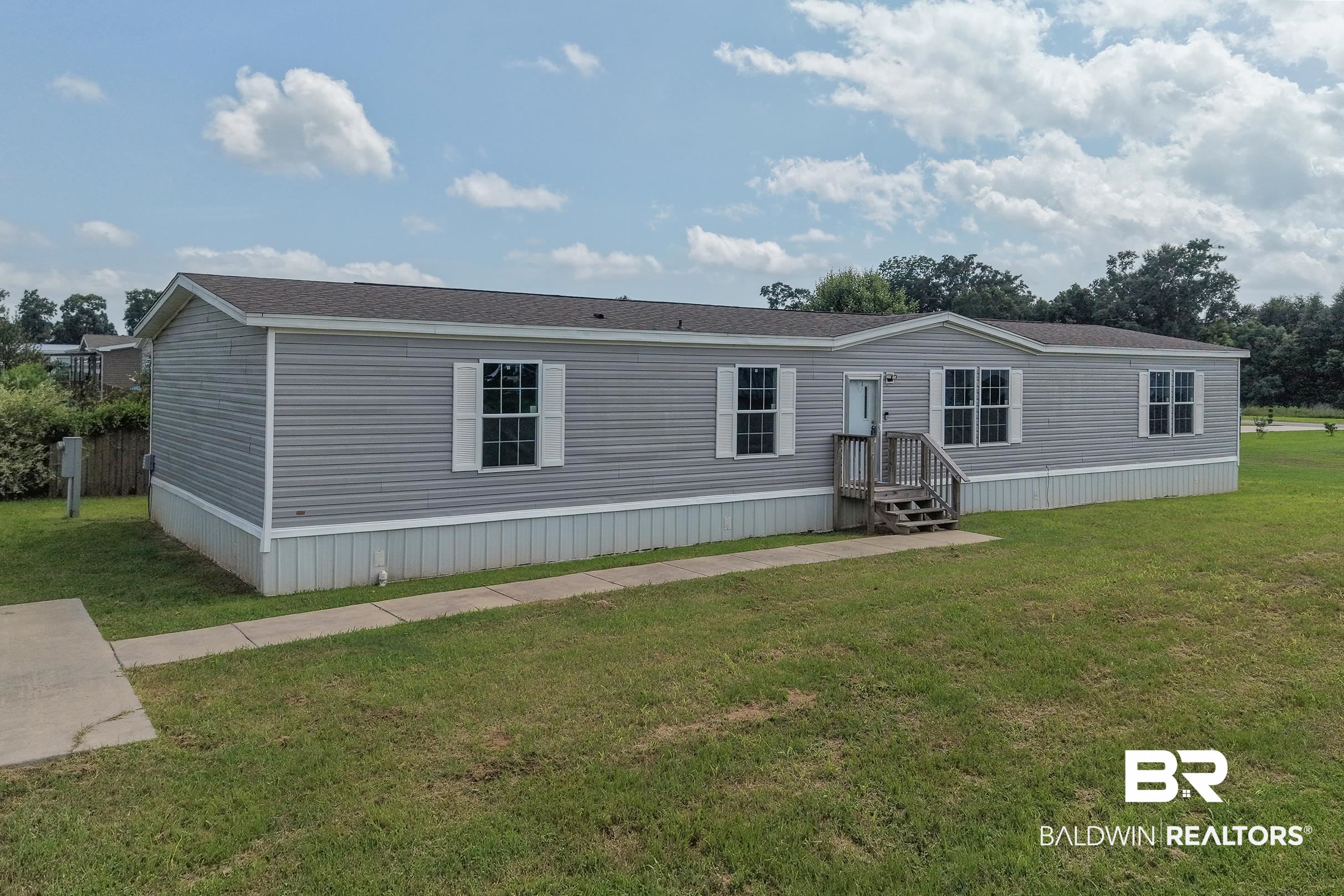21601 Westside Loop Silverhill, AL 36576 - Photo 1 of 42 Exterior features gray siding, white window shutters, and a dark shingle roof