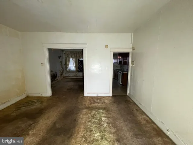 a view of an empty room with a fireplace and a window