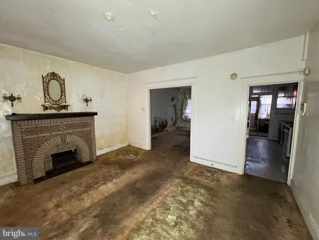 a view of empty room with fireplace and wooden floor
