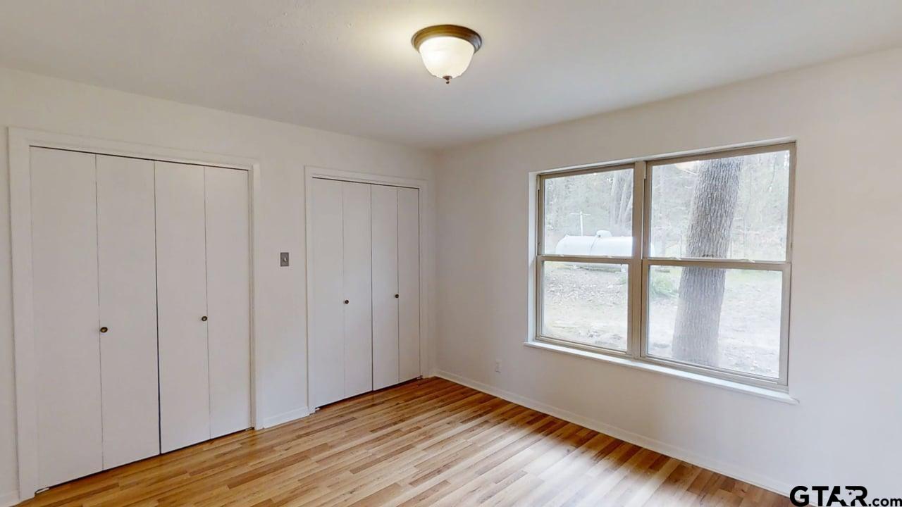 17035 Deer Run Road Flint, TX 75762 - Photo 14 of 31 a view of an empty room with a window and wooden floor