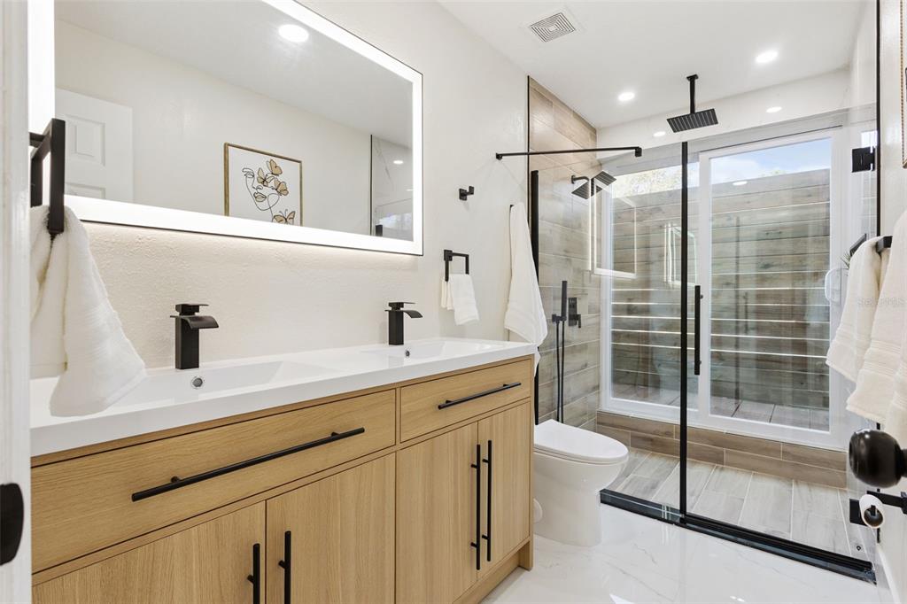 407 Forest Road Mount Dora, FL 32757 - Photo 15 of 35 a spacious bathroom with a shower sink mirror and toilet