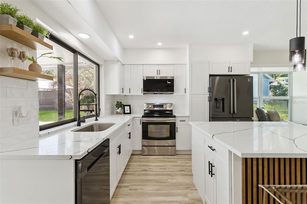 407 Forest Road Mount Dora, FL 32757 - Photo 10 of 35 a large kitchen with stainless steel appliances granite countertop a refrigerator and a stove top oven