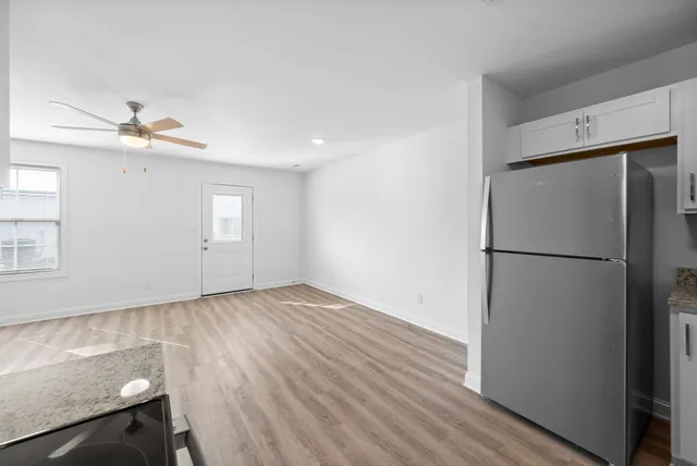 a view of empty room with wooden floor and window