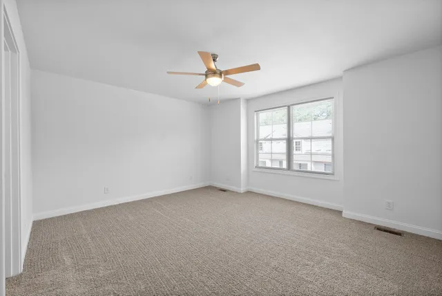 a view of an empty room with a ceiling fan
