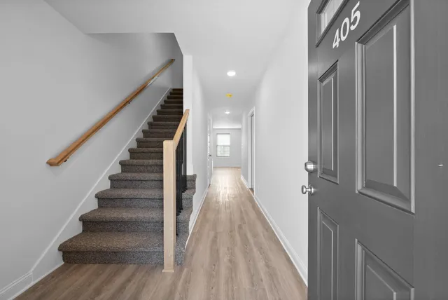 a view of a hallway with wooden floor and entryway