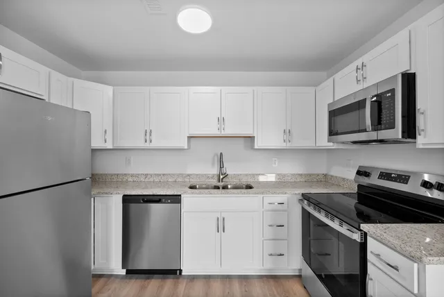 a kitchen with white cabinets stainless steel appliances and sink